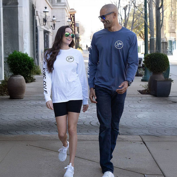 Guy and girl walking wearing white and navy long sleeve shirts laughing